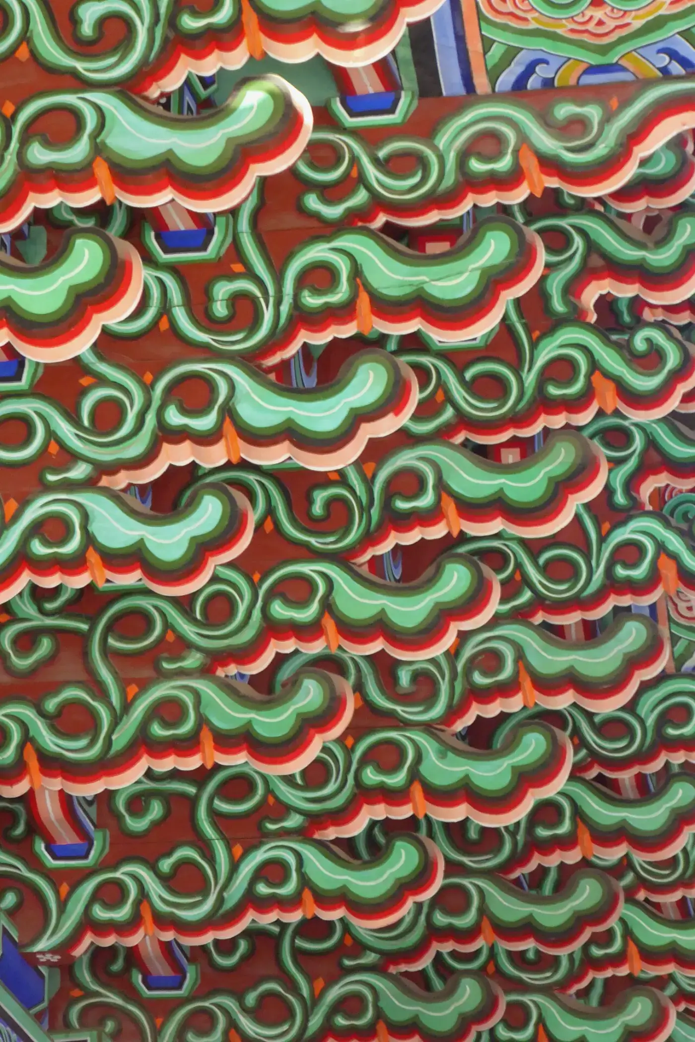 Green cloud-shaped dancheong motifs layered over a red ground in Geunjeongjeon