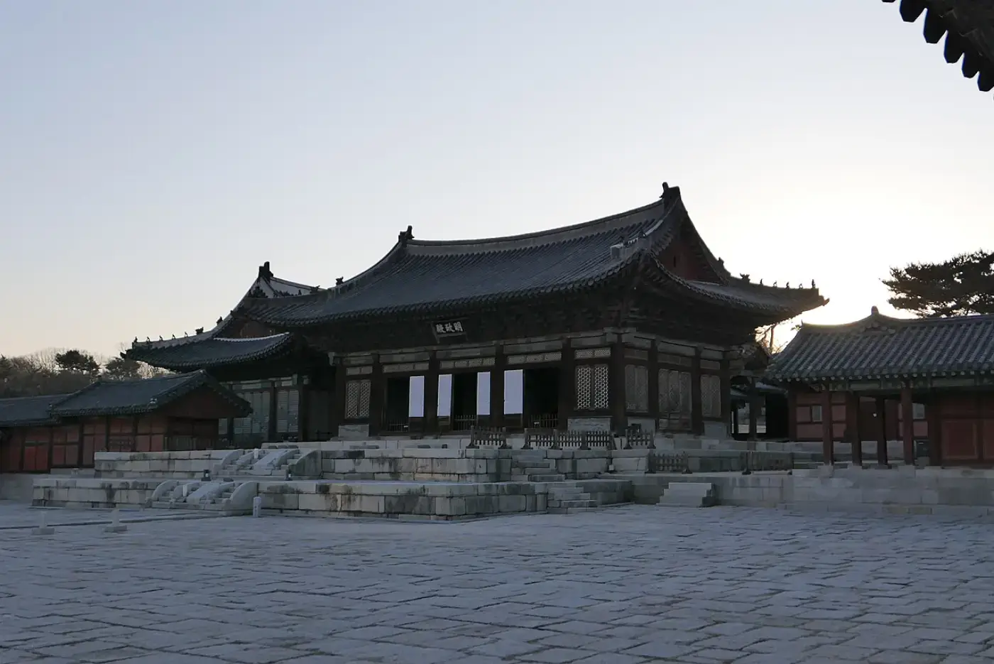 넓은 박석 마당 너머 돌기단 위에 선 창경궁 명정전의 정면과 측면