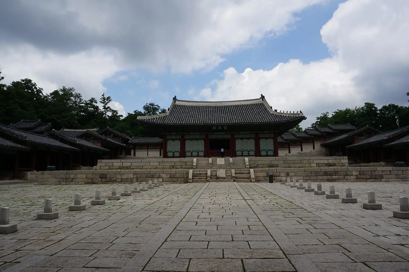 Restored Sungjeongjeon Hall of Gyeonghuigung on its stone terrace beyond a wide paved courtyard